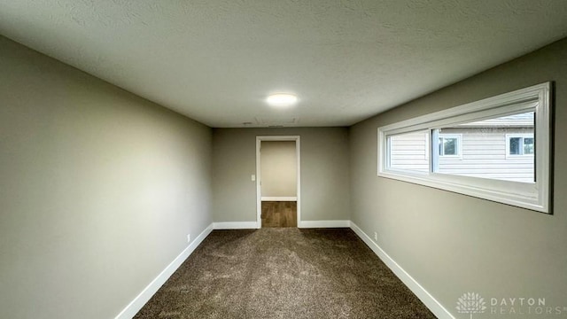 carpeted empty room featuring a textured ceiling