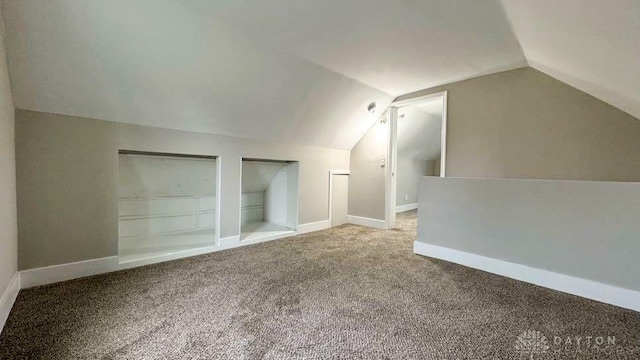 bonus room with built in features, carpet floors, and vaulted ceiling