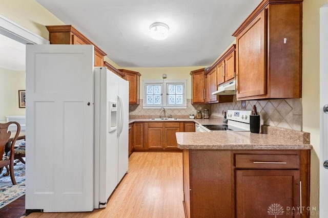 kitchen featuring decorative backsplash, sink, white appliances, and light wood-type flooring