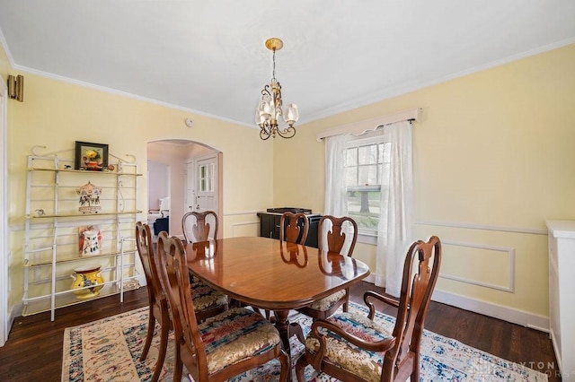 dining area featuring dark hardwood / wood-style floors, crown molding, and a notable chandelier