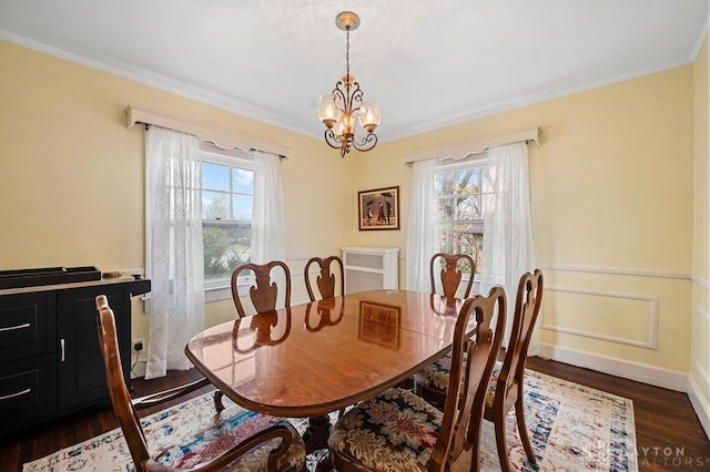 dining area featuring crown molding, dark hardwood / wood-style flooring, a chandelier, and plenty of natural light