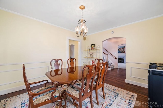 dining room with dark hardwood / wood-style flooring, an inviting chandelier, and ornamental molding