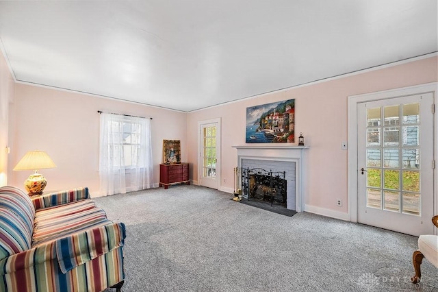 carpeted living room with a brick fireplace and crown molding