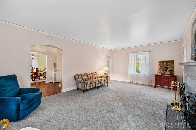 living room featuring a fireplace, carpet floors, and crown molding