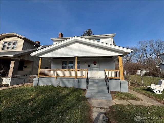 bungalow-style home with covered porch and a front lawn