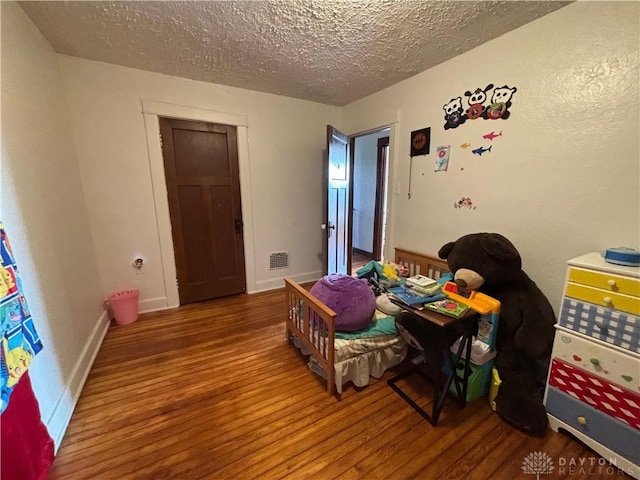 bedroom featuring hardwood / wood-style floors and a textured ceiling