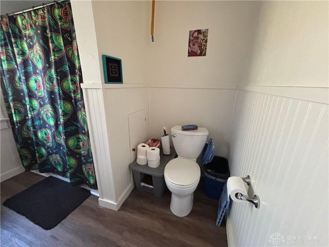 bathroom featuring hardwood / wood-style floors, a shower with curtain, and toilet