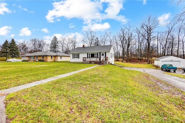 single story home with an outbuilding, a front lawn, covered porch, and a garage