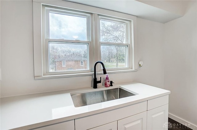 kitchen featuring white cabinetry and sink