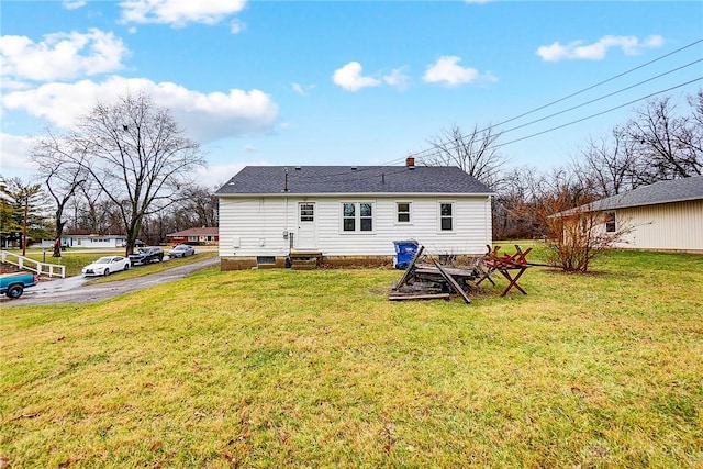 rear view of property featuring a lawn