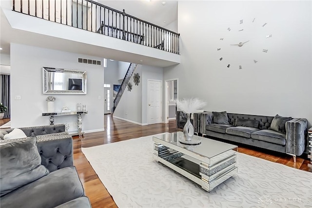 living room with hardwood / wood-style floors and a high ceiling