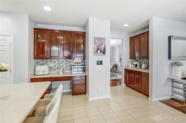 kitchen with light tile patterned flooring and backsplash