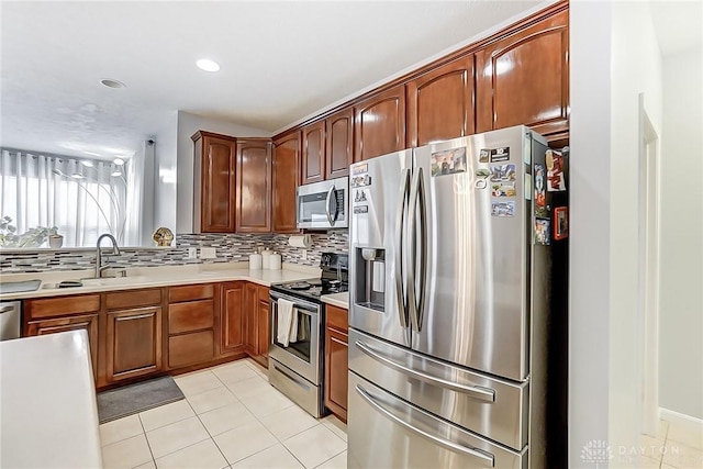 kitchen featuring sink, decorative backsplash, stainless steel appliances, and light tile patterned flooring