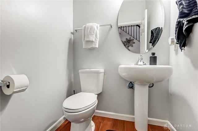 bathroom with hardwood / wood-style floors and toilet