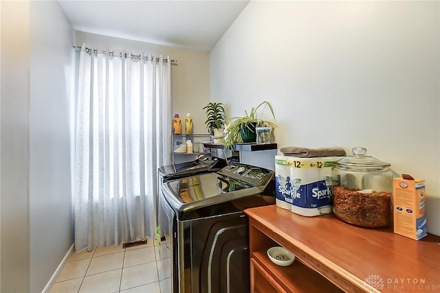 laundry area with plenty of natural light, washer and dryer, and light tile patterned floors