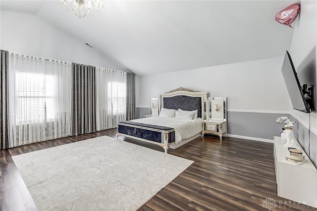 bedroom featuring dark wood-type flooring, an inviting chandelier, and vaulted ceiling