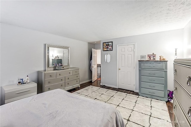 bedroom with a textured ceiling and light wood-type flooring