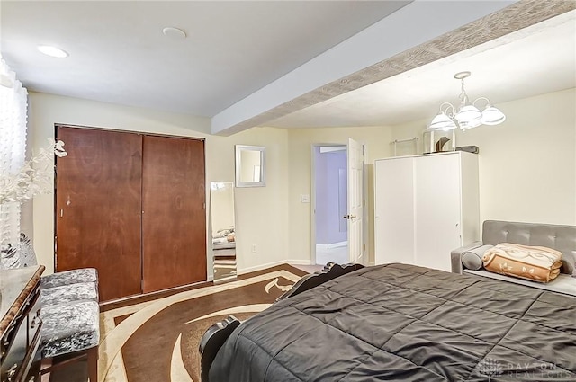 bedroom featuring beam ceiling, a closet, and a chandelier