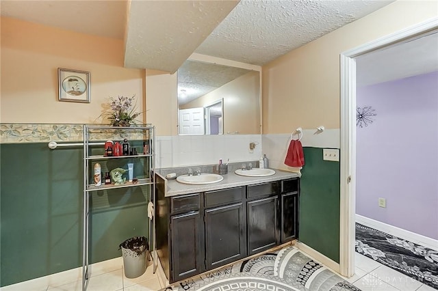 bathroom featuring tile patterned floors, vanity, and a textured ceiling