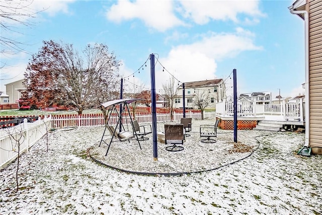 snow covered playground featuring a fire pit and a deck