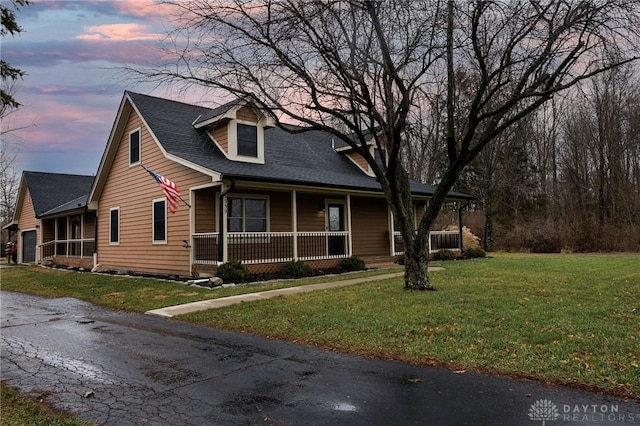 view of front facade with a lawn and covered porch