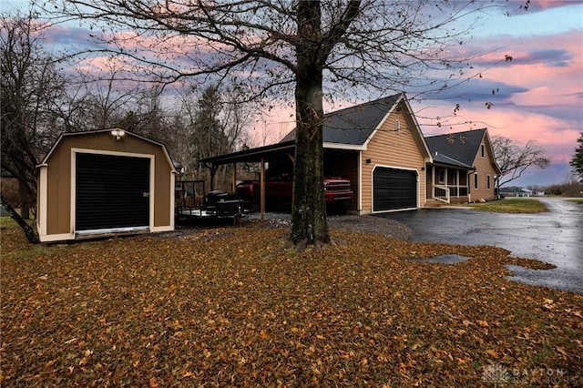 property exterior at dusk featuring a garage and a carport