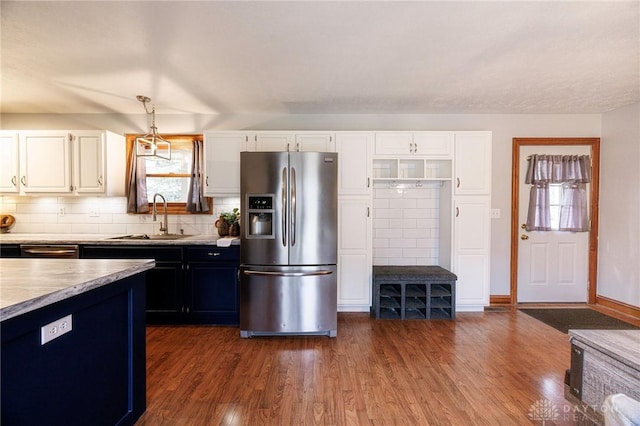 kitchen with sink, hanging light fixtures, dark hardwood / wood-style floors, stainless steel fridge, and white cabinetry