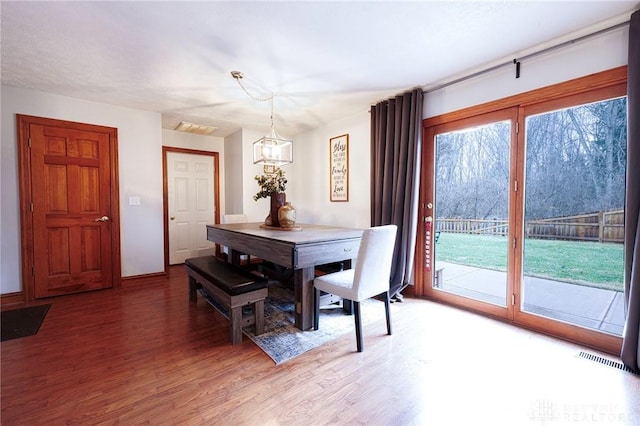 dining space with a chandelier and hardwood / wood-style flooring