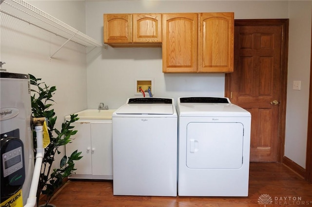 clothes washing area featuring sink, cabinets, washing machine and dryer, electric water heater, and dark hardwood / wood-style flooring