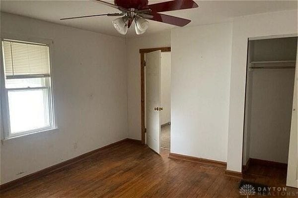 unfurnished bedroom featuring ceiling fan, a closet, and dark hardwood / wood-style floors