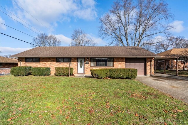 ranch-style home featuring a carport, a garage, and a front lawn