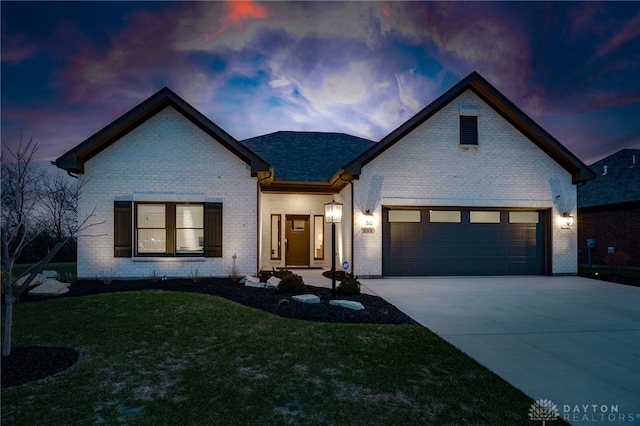 view of front of house with a garage and a yard