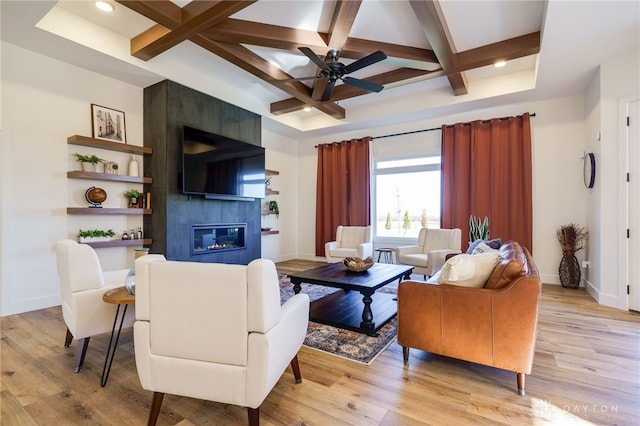 living room with coffered ceiling, light hardwood / wood-style flooring, ceiling fan, a fireplace, and beam ceiling