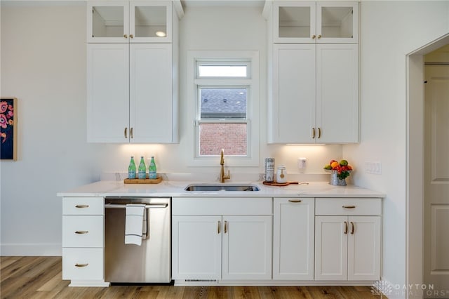 kitchen with white cabinetry, sink, stainless steel dishwasher, and light wood-type flooring