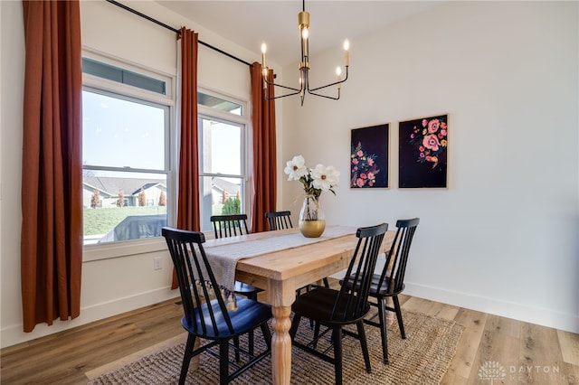 dining space featuring light hardwood / wood-style flooring and an inviting chandelier