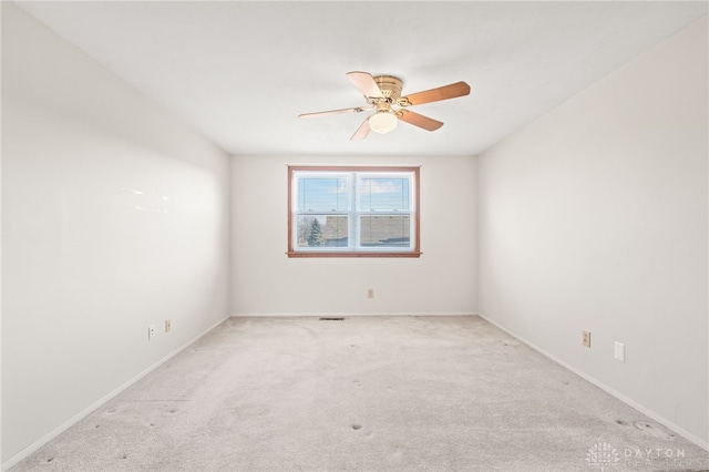 unfurnished room with light colored carpet and ceiling fan