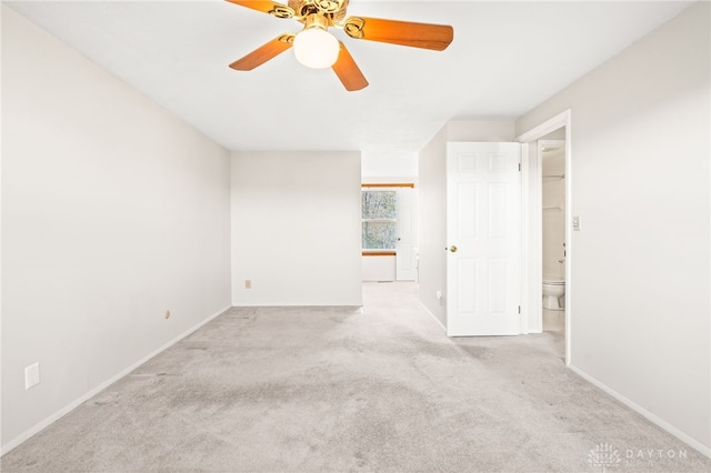 empty room featuring ceiling fan and light colored carpet