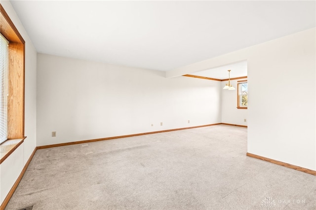 empty room with beamed ceiling, carpet floors, and a chandelier