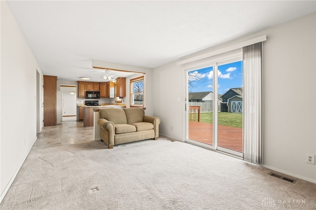 carpeted living room featuring ceiling fan