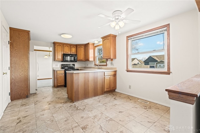 kitchen with kitchen peninsula, ceiling fan, and black appliances