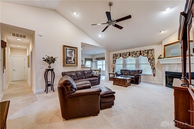 living room with ceiling fan, high vaulted ceiling, and light carpet