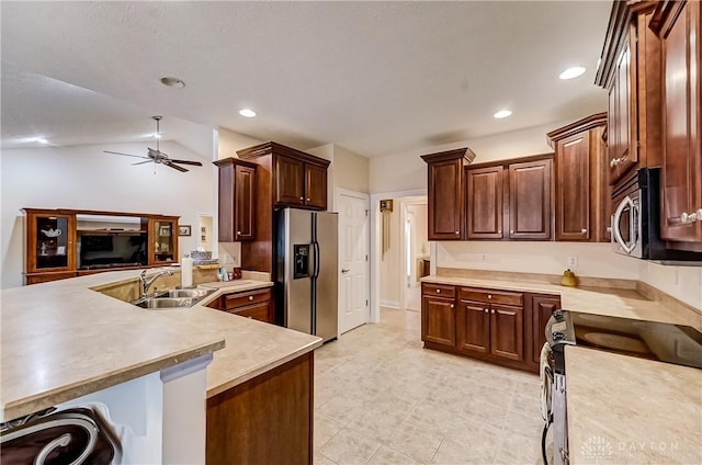 kitchen featuring appliances with stainless steel finishes, lofted ceiling, sink, kitchen peninsula, and ceiling fan