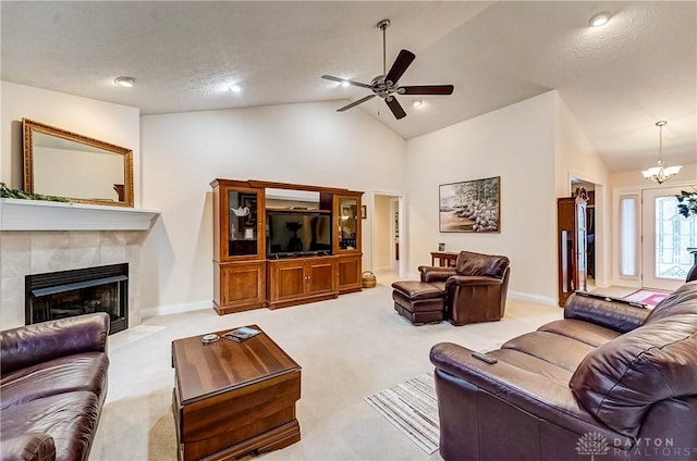 carpeted living room featuring ceiling fan with notable chandelier, lofted ceiling, and a fireplace