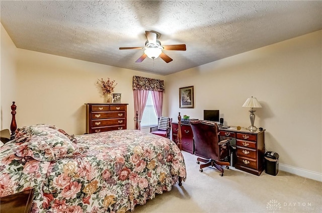 carpeted bedroom featuring ceiling fan and a textured ceiling