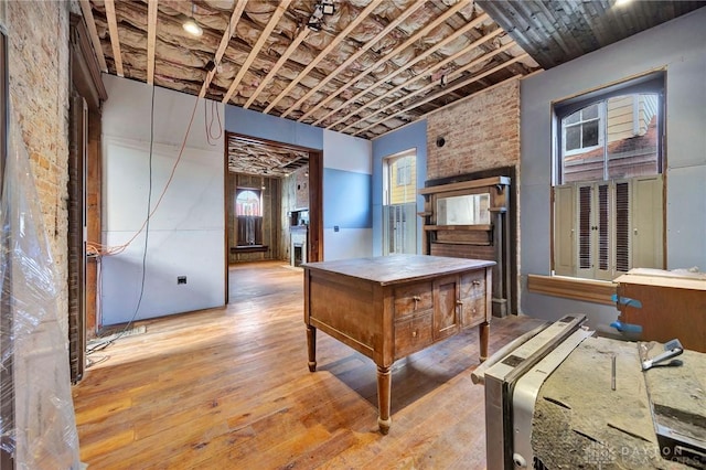 interior space featuring light hardwood / wood-style floors and brick wall