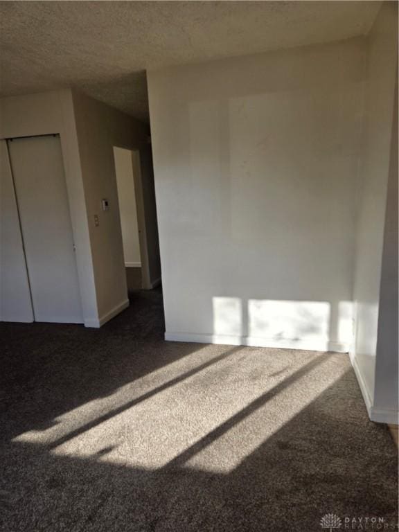 carpeted spare room featuring a textured ceiling