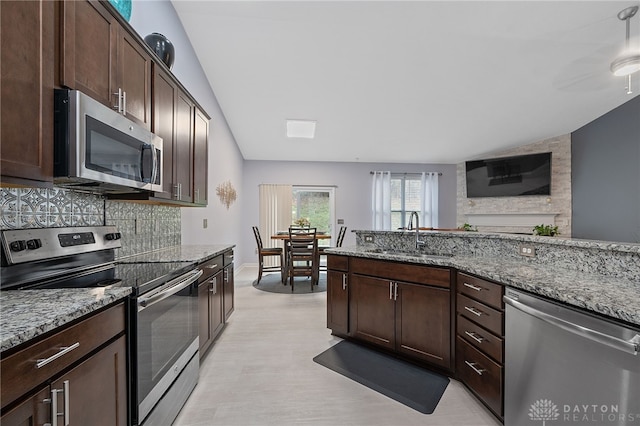 kitchen with dark brown cabinets, light stone countertops, sink, and appliances with stainless steel finishes