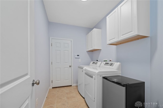 laundry room with cabinets, light tile patterned floors, and washing machine and dryer