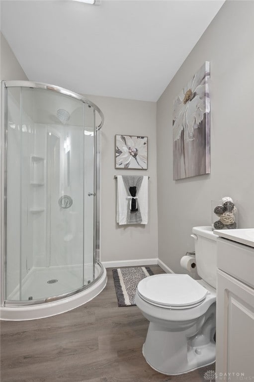 bathroom featuring vanity, hardwood / wood-style flooring, toilet, and an enclosed shower