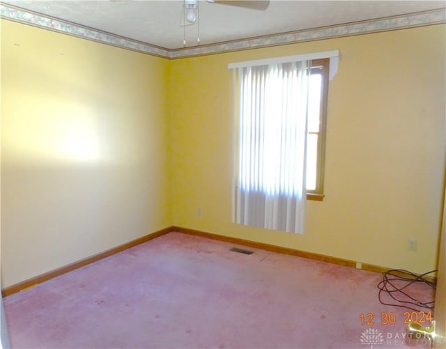 carpeted empty room featuring a wealth of natural light and ceiling fan